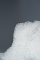 Fluffy white foam on a gray background.