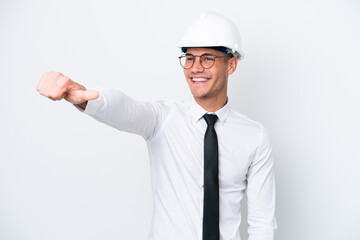Young architect caucasian man with helmet and holding blueprints isolated on white background giving a thumbs up gesture