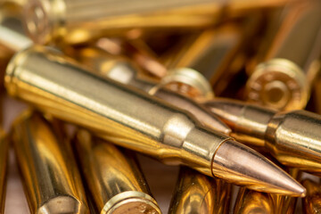 Obraz na płótnie Canvas A scattering of cartridges with 7.62 caliber bullets for the Kalashnikov assault rifle, close-up, selective focusing. Concept: sale of weapons under lend-lease, assistance with ammunition, supply of w