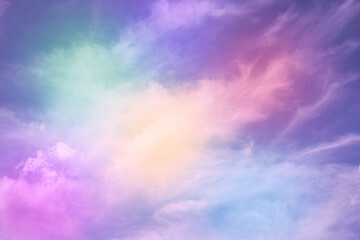 Rainbow sky with fluffy clouds. Abstract purple green yellow background with space for design. Multicolored toned sky with clouds. Beautiful fantasy skies. Magical, fantastic, fabulous, iridescent.