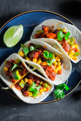 Vegetarian and healthy tacos made of tomatoes, avocado and hebrs.