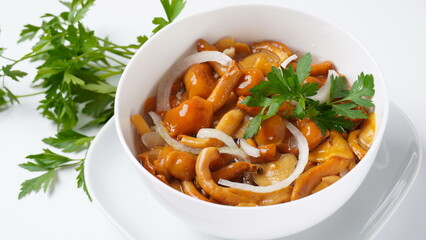 Marinated wild honey fungus Armillaria mellea mushrooms with spices and onions in the bowl.