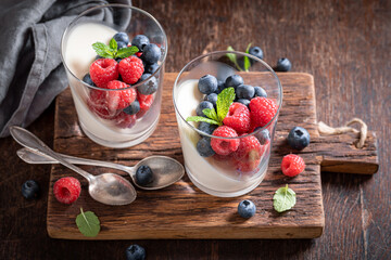 Homemade and tasty Panna Cotta served with berries in glass.