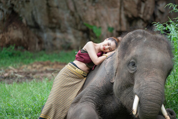 Beautiful woman wear traditional Thai dress with elephant.