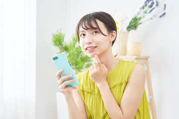 女性　スマホ　考える　リビング