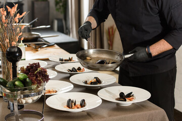 Obraz na płótnie Canvas chef prepares carrot cream soup with seafood in a restaurant