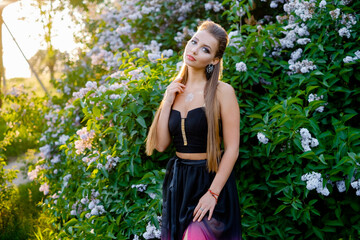 Woman in a summer dress on a near the bushes.