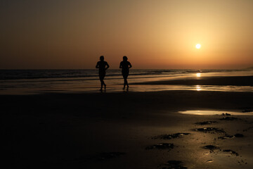 Fototapeta na wymiar long shot of two runners on a great spanish beach at sunset