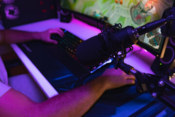 Hands of a young gamer playing video games in a gaming setup