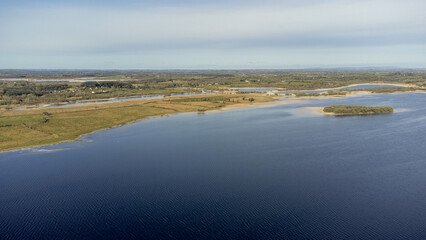 Aerial view of a forest lake. Aerial view of lake and forest boarder on a sunny summer day. Drone photography.