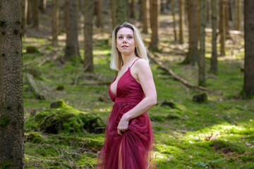 Beautiful woman looking away standing at forest.