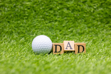 Golf ball with word Dad on green grass