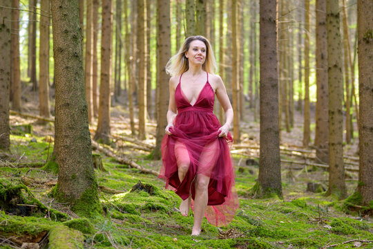 Beautiful woman in sexy gown running at forest.