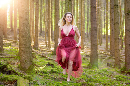.Attractive woman in sexy dress running at forest.