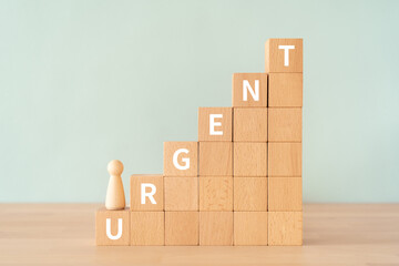 緊急のイメージ｜「URGENT」と書かれた積み木と人形