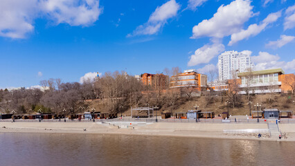 City embankment on the Amur River in Khabarovsk in early spring. A sunny day. The ice on the river...