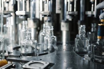 Filling glass bottles with liquid.