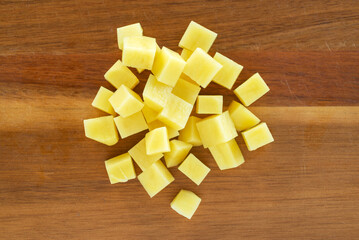 raw sliced potatoes on on wooeden cutting board background.