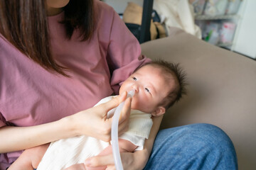 Obraz na płótnie Canvas 鼻吸い機と赤ちゃん