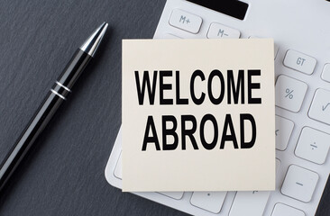 Text WELCOME ABROAD on sticker on the calculator, business concept
