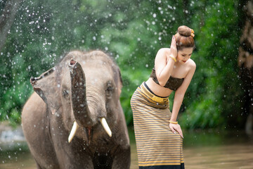 An elephant spraying water on a girl