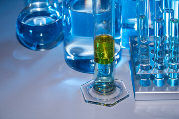 Laboratory equipment such as beaker, flask, cylinders and test tubes under a bluish light