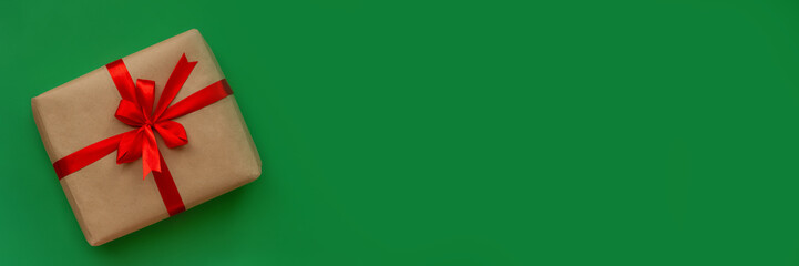 banner gift in craft paper and red ribbon with bow on green background
