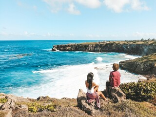 Couple on a romantic getaway, looking at the ocean in Barbados