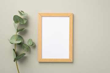 Business concept. Top view photo of wooden photo frame and eucalyptus branch on pastel grey...