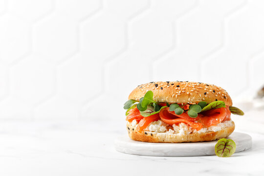 Healthy Breakfast Food. Bagel Sandwich With Salmon, Cream Cheese And Micro Greens On  Board And White Background. Burger With Salmon.