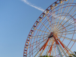 Ferris wheel against the sky. Amusement park on the sea. Rest zone.