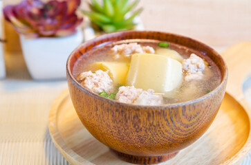 Minced pork and soya bean curd soup in wooden bowl.