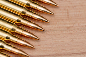 A row of cartridges with 7.62 caliber bullets for a Kalashnikov assault rifle on a textured...