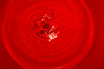 water abstract red background, idyllic romantic scene a drop that seems to make a rose out of water