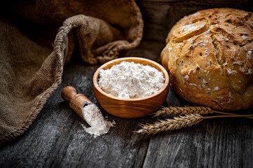 Fototapeta na wymiar Wheat flour on an old wooden table