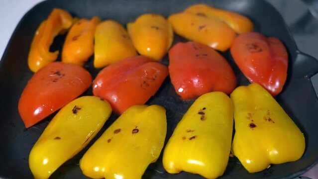 cooking red and yellow pappers with hot cooking plate - grill the vegetables