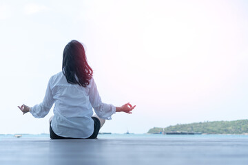 Class of yoga with meditate hands of Asia woman doing meditation in sunrise and lens flair...