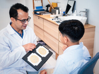 Handsom Indian optometrist gets color blindness tested child boy patient at the modern clinic....