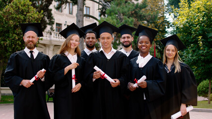 Group of multiracial graduates students posing happy in front of the camera in the graduation day...