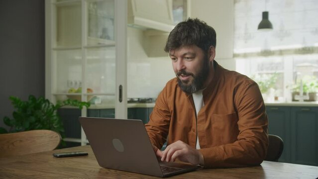 Portrait of a young adult caucasian man recieving good news on his laptop