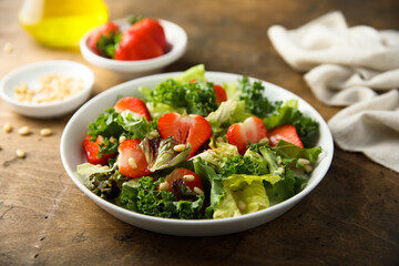 Healthy green salad with strawberry and pine nuts