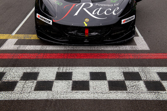 Detail of race car in pole position starting grid, Lotus Elise on checkered line racetrack