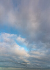 Fototapeta na wymiar Fantastic clouds at sunrise, vertical panorama