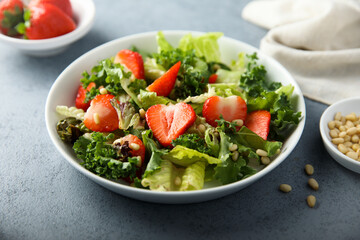 Healthy green salad with strawberry and pine nuts