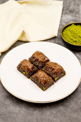 Chocolate baklava. Chocolate baklava with pistachio on dark background. Mediterranean cuisine delicacies. Close-up. local name cikolatali baklava