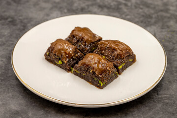 Chocolate baklava. Chocolate baklava with pistachio on dark background. Mediterranean cuisine delicacies. Close-up. local name cikolatali baklava