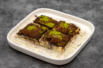 Dark chocolate baklava. Baklava with milk on a dark background. Mediterranean cuisine delicacies. Close-up. Local name bitter soguk baklava