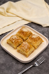 Milk baklava. Baklava with hazelnuts on a dark background. Mediterranean cuisine delicacies. Close-up. local name sutlu nuriye baklava