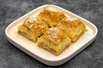 Milk baklava. Baklava with hazelnuts on a dark background. Mediterranean cuisine delicacies. Close-up. local name sutlu nuriye baklava