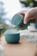 Young girl pouring tea from teapot close-up
